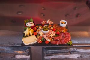 een dienblad met vleeskaas en andere voedingsmiddelen bij Eden House, Cocon intimiste et romantique avec jacuzzi in Carpentras