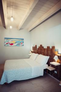 オルトーナにあるB&B Il Mare In Una Stanzaのベッドルーム1室(ベッド1台付)が備わります。壁には絵画が飾られています。