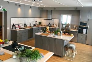 a large kitchen with gray cabinets and a table at Rimforsa Strand in Rimforsa