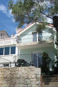 una casa blanca con una valla delante en Smokva Apartments, en Herceg-Novi