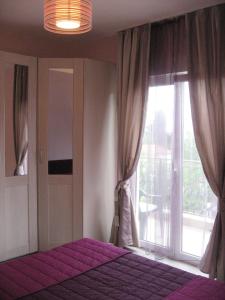 1 dormitorio con cama y ventana grande en Smokva Apartments, en Herceg-Novi