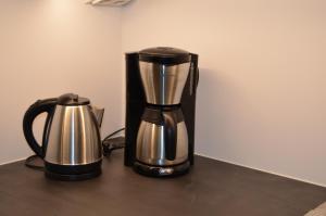 a coffee maker and a kettle on a table at Lahti Hietaneilikka Apartments in Lahti