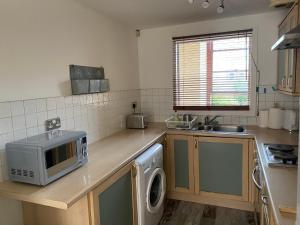 a kitchen with a microwave on a wooden counter at Lovely 1-Bed Apartment in Glasgow Merchant City in Glasgow