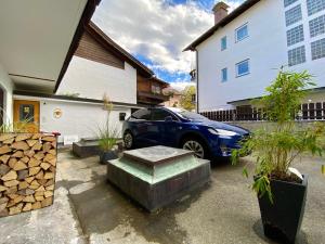 um carro azul estacionado em frente a uma casa em "Mittendrin" in Garmisch em Garmisch-Partenkirchen