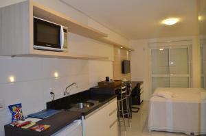eine Küche mit einem Waschbecken und ein Bett in einem Zimmer in der Unterkunft Executive 206 Sem Garagem in Caxias do Sul