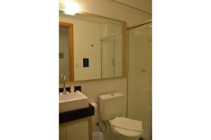 a bathroom with a toilet and a sink and a mirror at Executive 206 Sem Garagem in Caxias do Sul