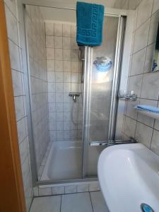 a bathroom with a shower and a tub and a toilet at Haus am Bürgerpark Hage OG in Hage