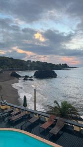 a view of a beach with chairs and the ocean at Vinha da Areia Beach Hotel in Vila Franca do Campo