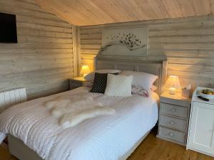 1 dormitorio con 1 cama con manta blanca en Adorable Cabin in the Countryside en Portlaoise