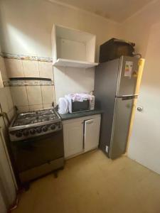 a small kitchen with a stove and a refrigerator at Casa la serena condominio D. Gabriela in La Serena