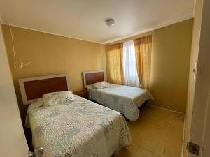 1 Schlafzimmer mit 2 Betten und einem Fenster in der Unterkunft Casa la serena condominio D. Gabriela in La Serena