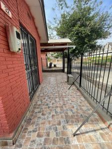 un bâtiment en briques avec un portail et un trottoir en briques dans l'établissement Casa la serena condominio D. Gabriela, à La Serena