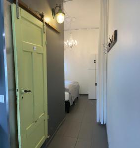 a hallway with a green door and a bedroom at Mörk Guesthouse in Hveragerði