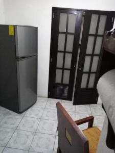eine Küche mit einem Edelstahlkühlschrank und einer Tür in der Unterkunft Apartamento Vacacional con A/C in Cozumel