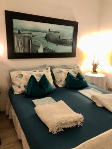 - un lit avec des oreillers verts et un tableau mural dans l'établissement Haus Senter, 