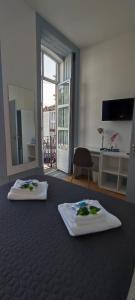 two towels are sitting on a bed in a room at Vila Santa Cruz Guest House in Braga