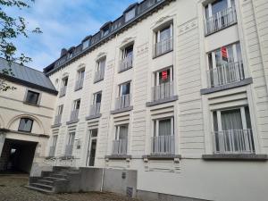 duży biały budynek z oknami i balkonami w obiekcie Logement dans le cœur historique de Mons w mieście Mons