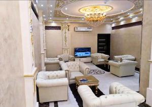 a living room with white furniture and a chandelier at الغبيشى بلازا in Jeddah