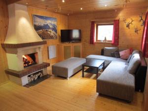 a living room with a couch and a fireplace at Zirbenwald Lodge in Turracher Hohe