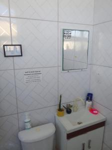 y baño con aseo, lavabo y espejo. en Salvador Dance-Hall Cuartos Privados, en Salvador