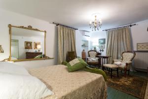 een slaapkamer met een bed, een spiegel en een tafel bij Le Giuggiole 5 posti letto in una casa ricca d'atmosfera in Farra dʼlsonzo
