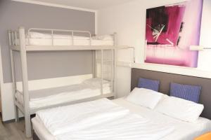 1 Schlafzimmer mit 2 Etagenbetten und 1 Bett in der Unterkunft hogh Hotel Heilbronn in Heilbronn