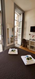 two white towels sitting on a table in a room at Vila Santa Cruz Guest House in Braga