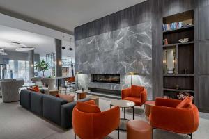 a living room with a fireplace and orange chairs at Radisson Blu Latvija Conference & Spa Hotel, Riga in Rīga