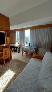 - une chambre avec 2 lits, une table et un bureau dans l'établissement Cosy Apartment in Fantastic Location in City Center, à Poços de Caldas