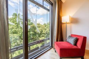 a red chair in a room with a large window at Radisson Blu Elizabete Hotel, Riga in Rīga