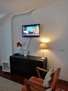 a living room with a tv on a wall at Apartamento Silveira in Furnas