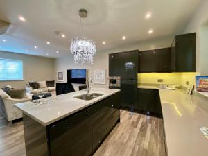 a kitchen with a sink and a living room at Executive Boutique Holiday Home - CS in Southport