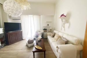 a living room with a white couch and a tv at 150m² Live/Work Unique&Sunlit Space in Athens in Athens
