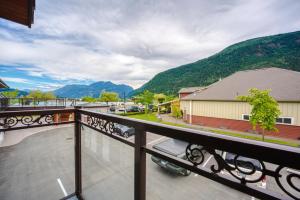 balcón con vistas a un edificio y a las montañas en Harrison Grand Motel en Harrison Hot Springs