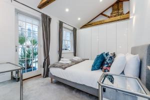 um quarto com uma cama e uma janela em London Choice Apartments - South Kensington - Mews House em Londres