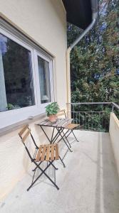 uma mesa e cadeiras num alpendre com um vaso de plantas em Ferienwohnung Schwarzwaldblick em Vörstetten