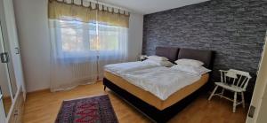 1 dormitorio con cama y pared de ladrillo en Ferienwohnung Schwarzwaldblick, en Vörstetten