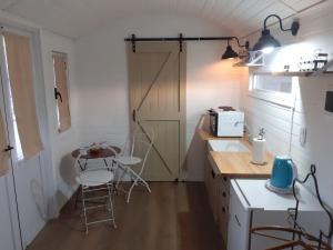 een keuken met een deur en een tafel en stoelen bij Las Nativas de Areco in San Antonio de Areco