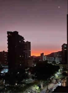 vista para uma cidade ao pôr-do-sol com edifícios em Cosy Apartment in Fantastic Location in City Center em Poços de Caldas