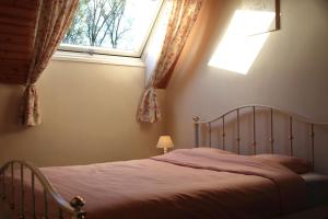 a bed in a bedroom with a window at B&B Adem in Horebeke