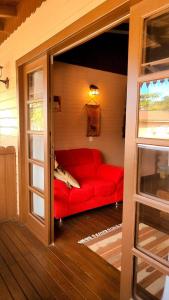 a living room with a red couch in a room at Pousada Casa do Oscar in Governador Celso Ramos