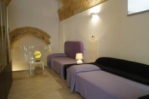 a room with two beds and a table with a lamp at S@sso Matto in Matera