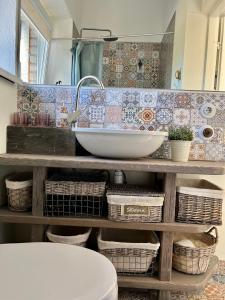 a bathroom with a sink and a counter with baskets at Zeltāres in Jelgava