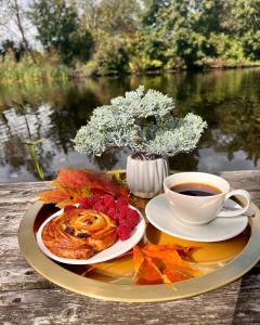 un plato de comida y una taza de café sobre una mesa en Zeltāres, en Jelgava