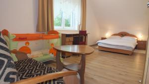 uma pequena sala com um quarto com uma cama e uma mesa em Leśny Domek 