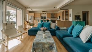 una sala de estar con sofás azules y una mesa. en Crystal Villa Patras en Patras