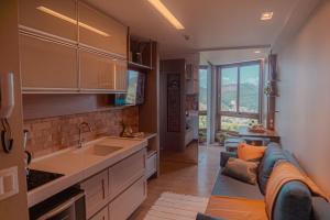 a kitchen with a couch and a sink in a room at Blue Flat Pedra Azul - Com Vista pra Pedra in Pedra Azul