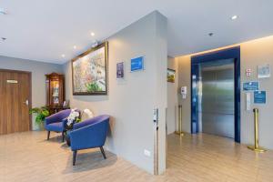 a waiting room with two blue chairs and an elevator at Amp Am House Bangkok Hotel in Bangkok