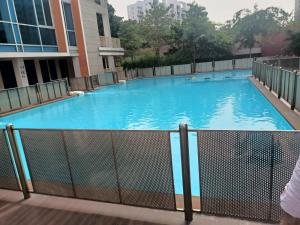 - une grande piscine dans un bâtiment d'eau bleue dans l'établissement Royal Suites - 3 rooms Appt -Blue, à Pune