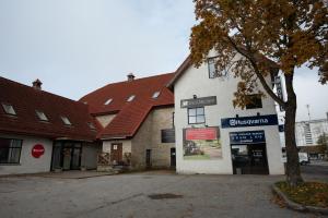 a white building with a red roof on a street at Aiakeskuse hostel in Rakvere